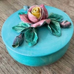 Antique turquoise dish with lid and ceramic roses on top.